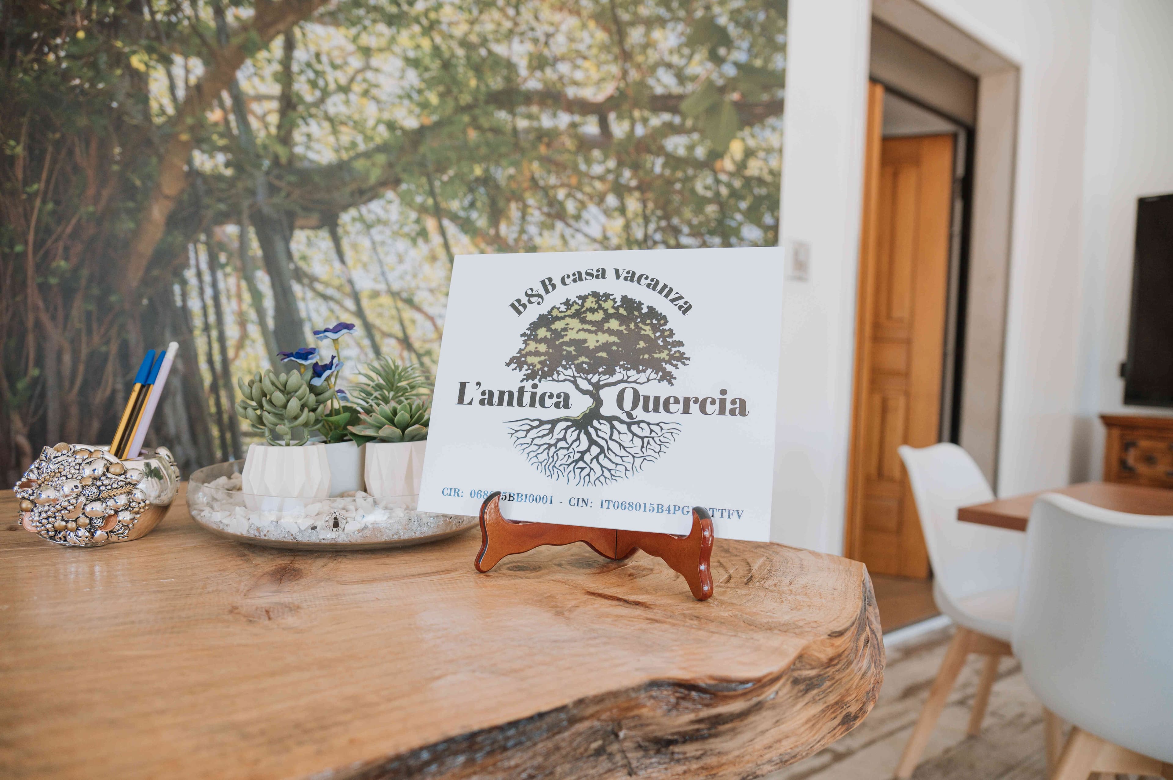 Insegna de L'Antica Quercia B&B su tavolo in legno