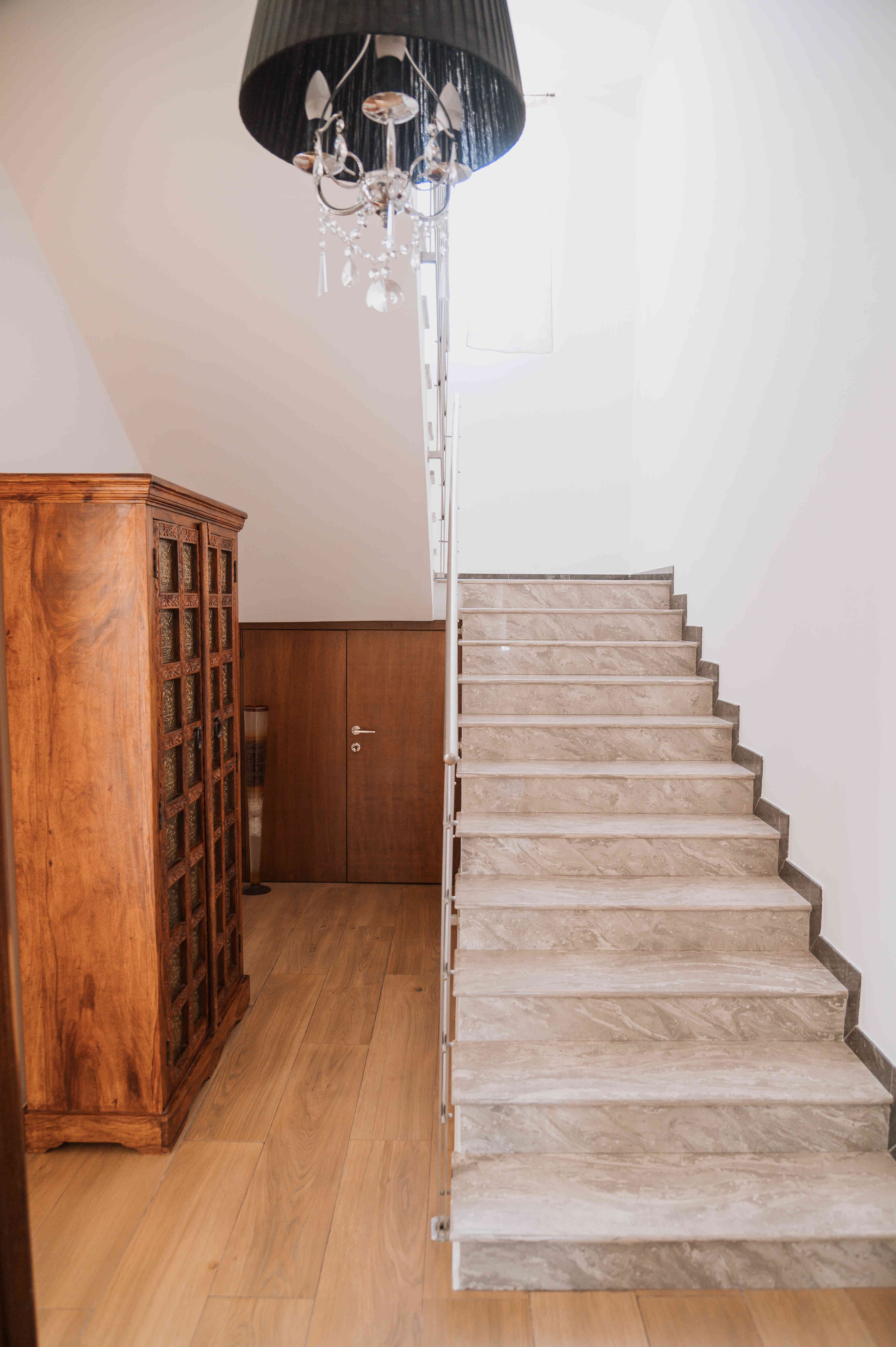 Scala interna de L'Antica Quercia con gradini in marmo e lampadario