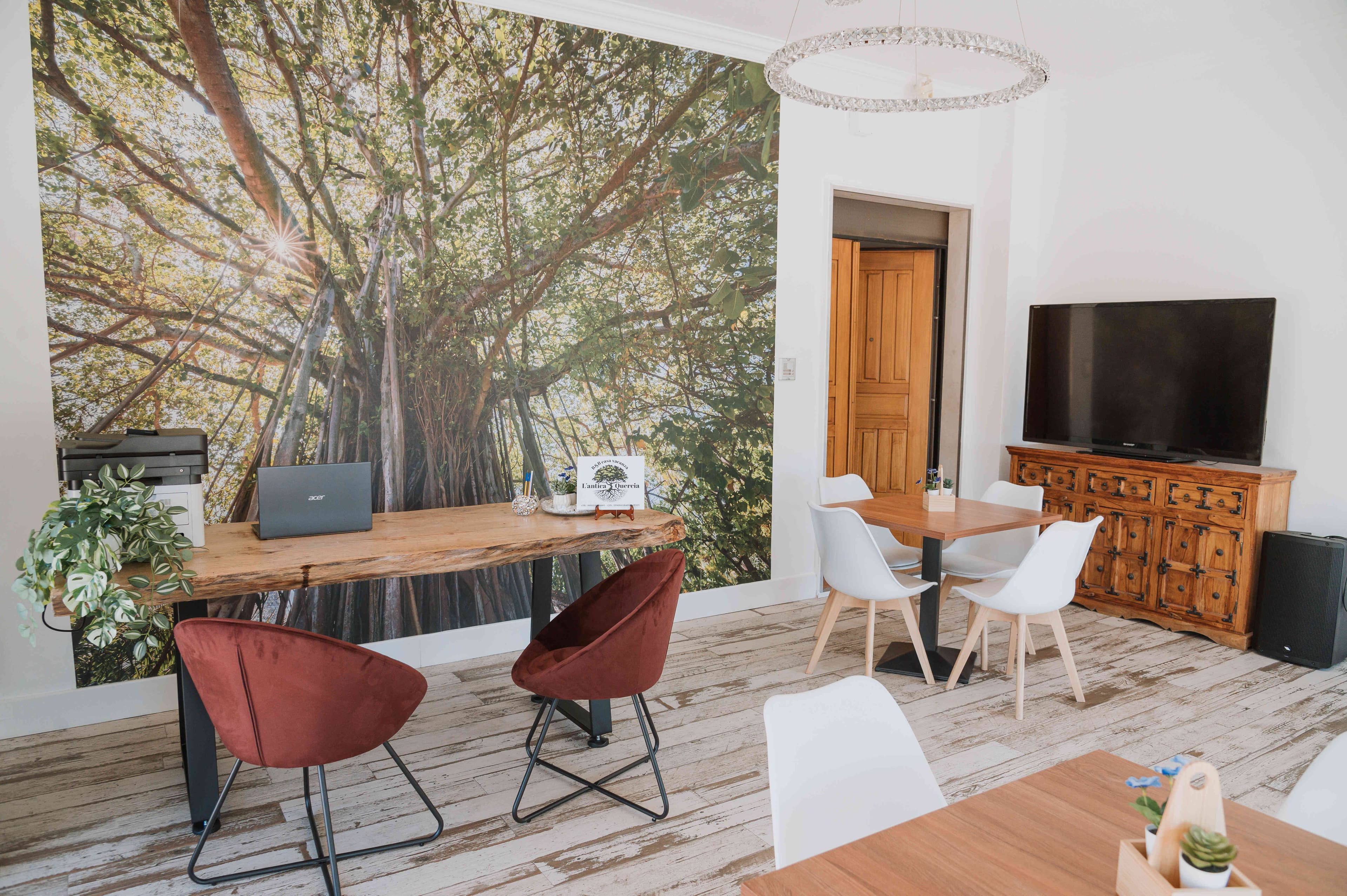 Sala comune de L'Antica Quercia con murales e arredi in legno